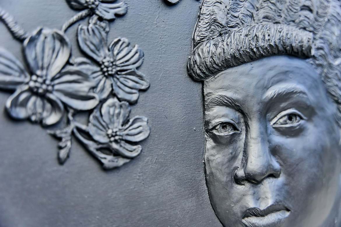 A closeup of the "Memoirs of Erma Hayman" bas-relief sculpture featuring Miss Erma as a young girl cast in bronze resin.
