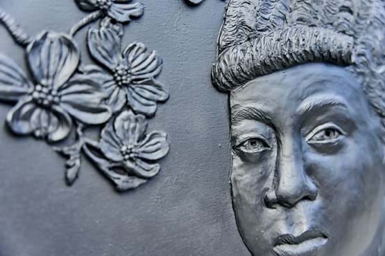 A closeup of the "Memoirs of Erma Hayman" bas-relief sculpture featuring Miss Erma as a young girl.
